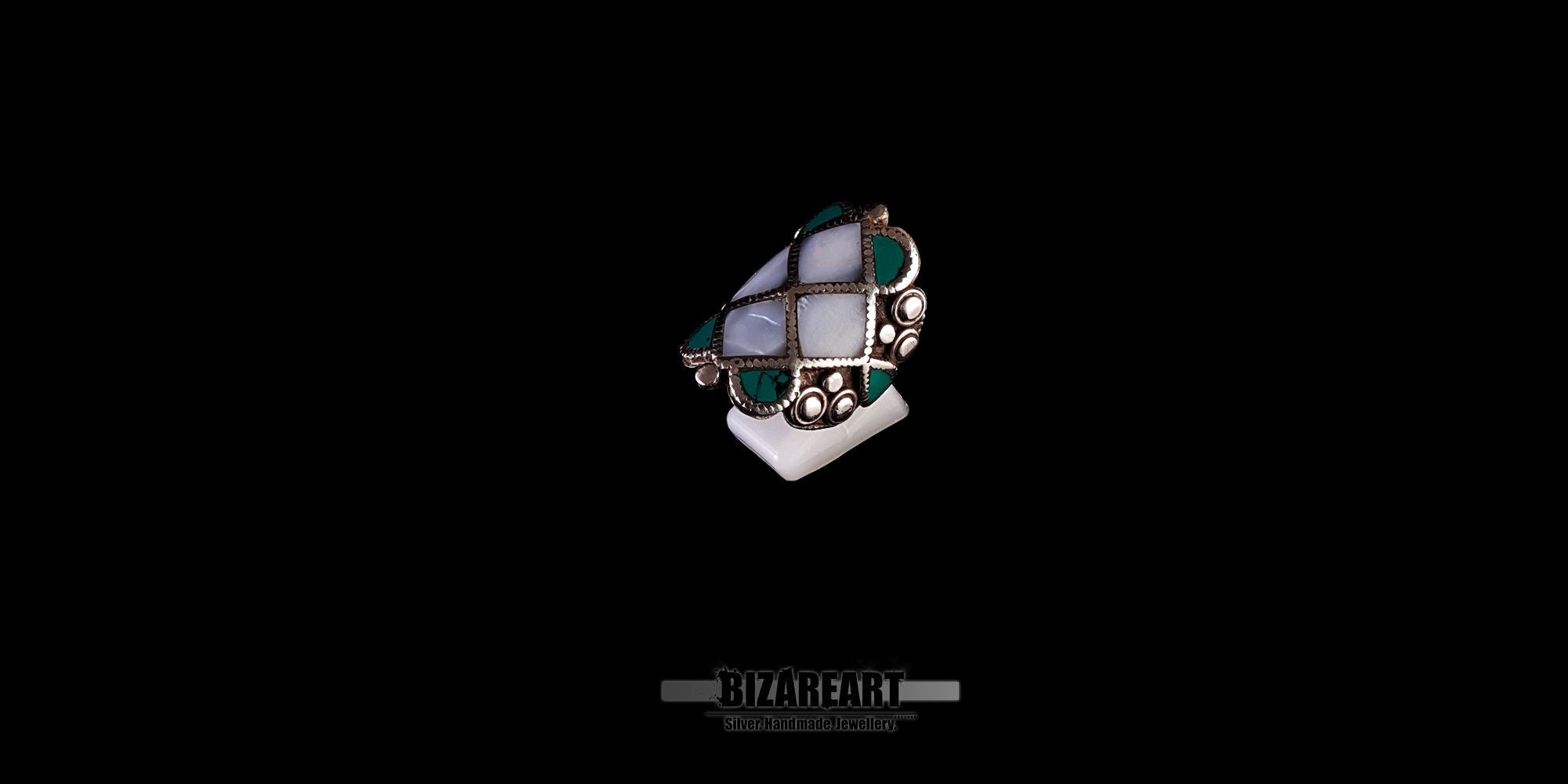 Three-quarter view of the large geometric Tibetan statement ring on a display stand, showcasing the natural variations in the turquoise.