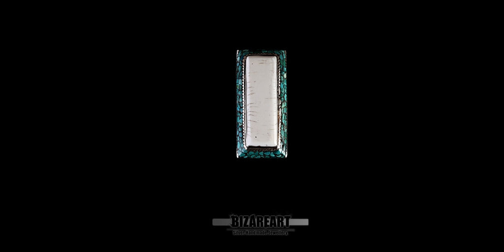 Direct top-down view of a rectangular Himalayan silver statement ring showing the long white conch shell center bordered by vibrant turquoise inlay stones.