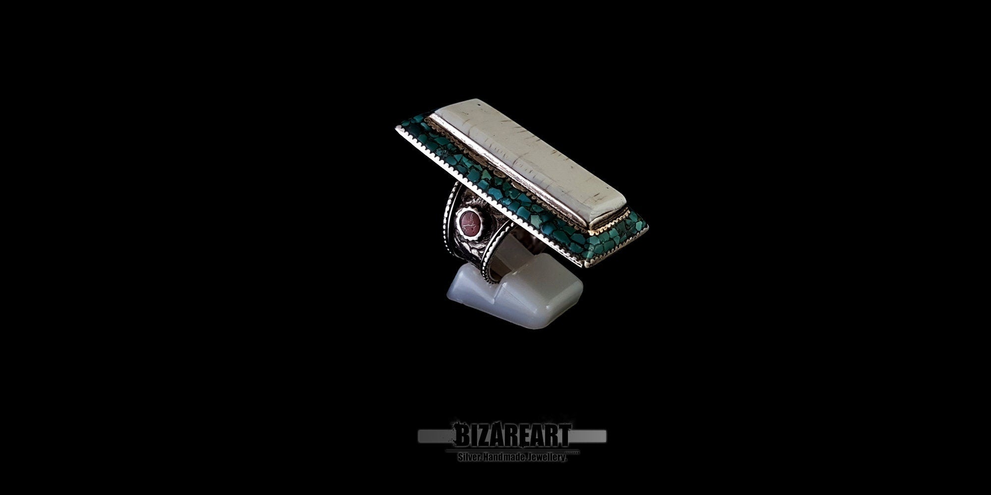 Three-quarter top view of a vintage Himalayan silver ring, highlighting its geometric design, raised conch center, and engraved silver border.