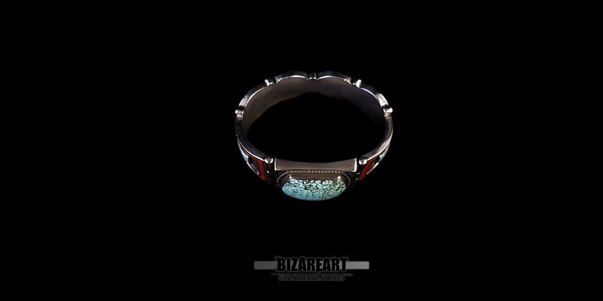 A look inside the cuff of the open bracelet, showing the inner silver lining and the structural construction behind the set stones and mosaic panels. Set against a black background.
