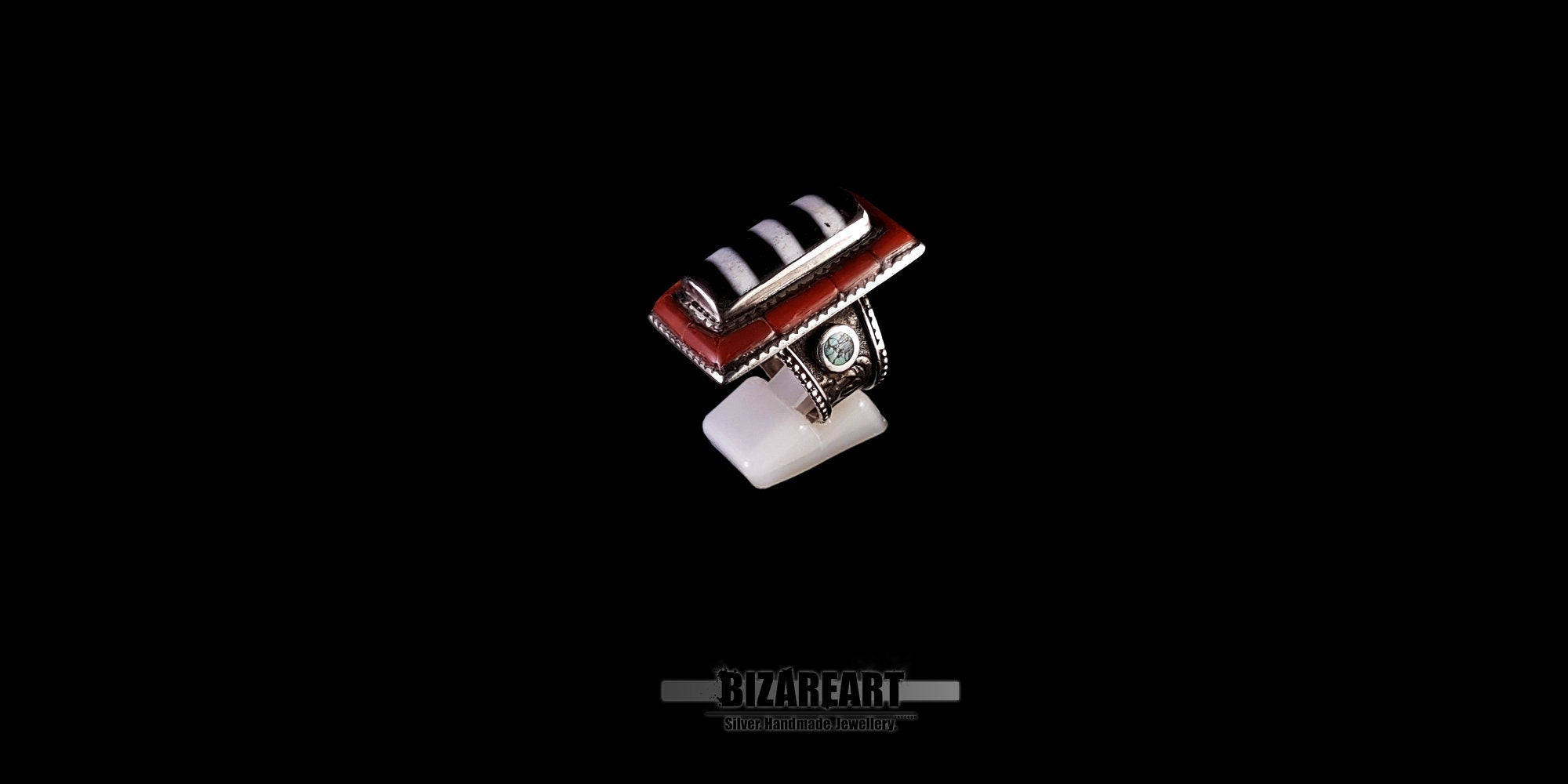 Front angled perspective of a 1900s Tibetan silver statement ring with a raised bezel setting on a white display stand.