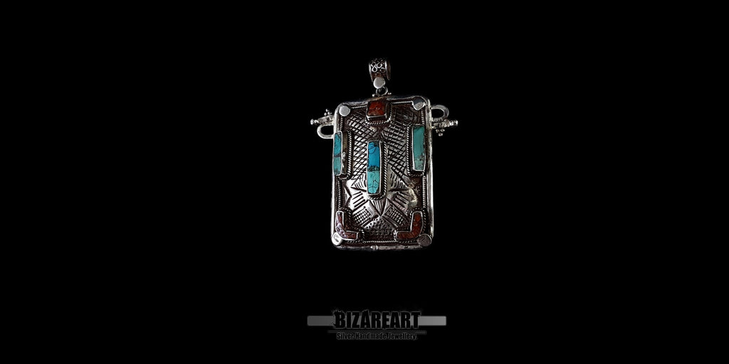 Close-up side view of hammered sterling silver texture and genuine Himalayan turquoise settings on a collectible pendant.