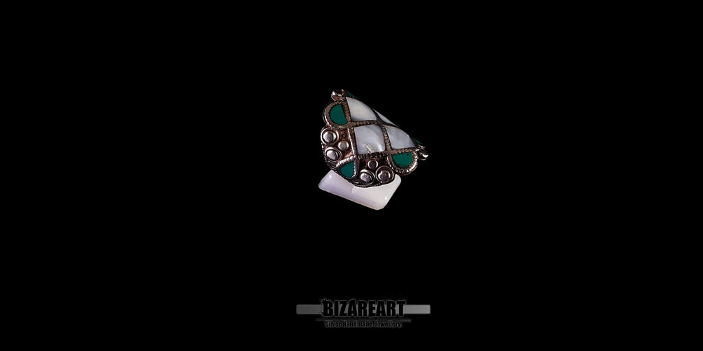 High-angle view of the vintage silver Himalayan ring, emphasizing the contrast between the white conch and blue-green turquoise stones.