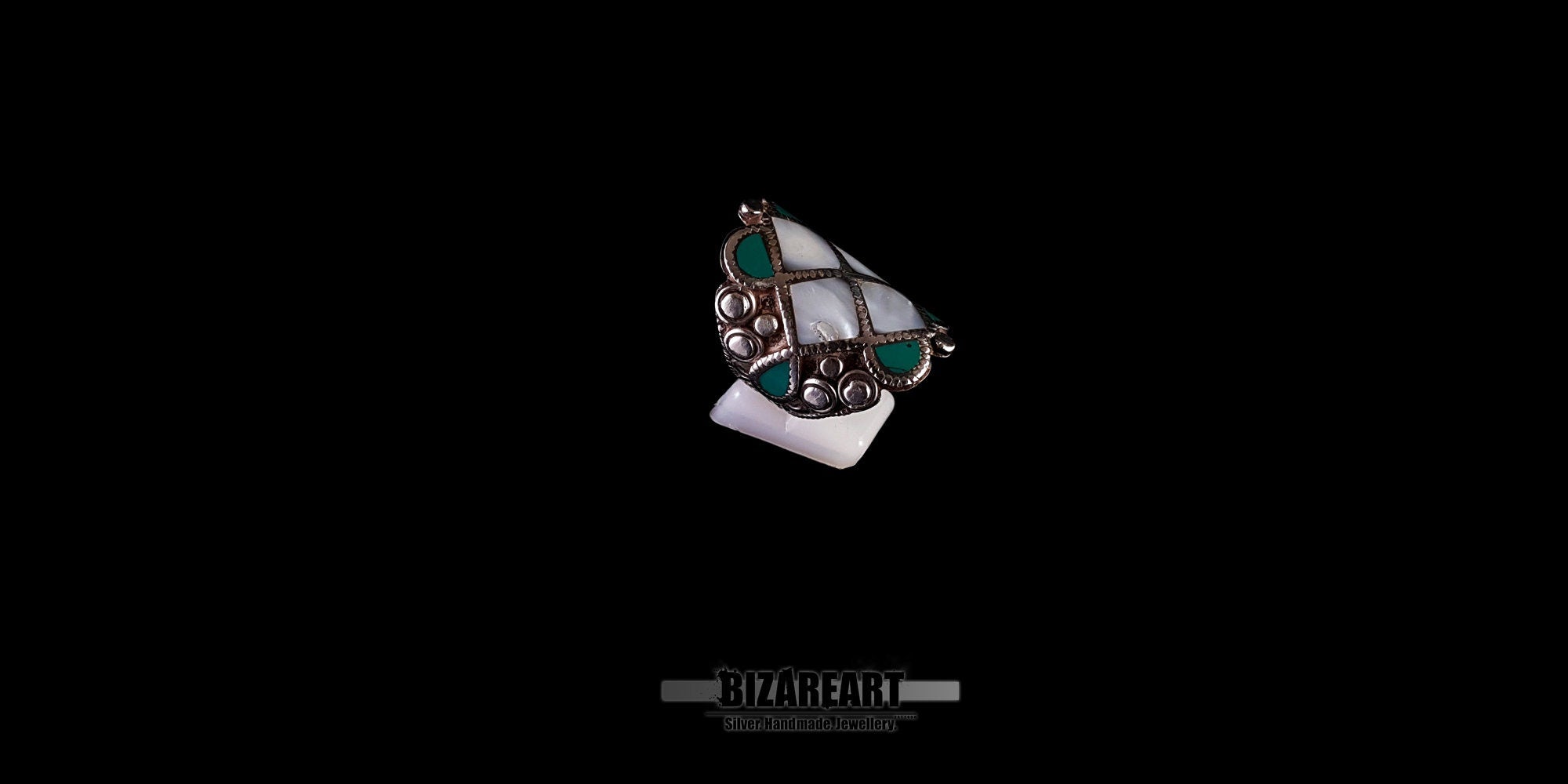 High-angle view of the vintage silver Himalayan ring, emphasizing the contrast between the white conch and blue-green turquoise stones.
