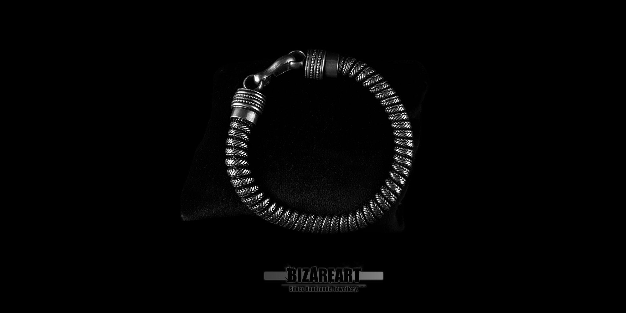 Top-down view of a thick silver snake chain bracelet showing the intricate industrial texture of the links.