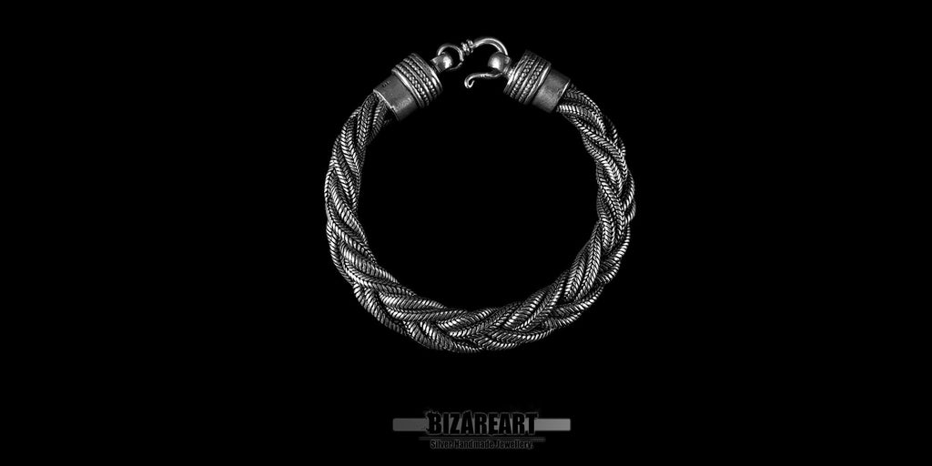 Handmade oxidized sterling silver triple rope bracelet by Bizareart, laid flat on a black background showing its detailed hook clasp.