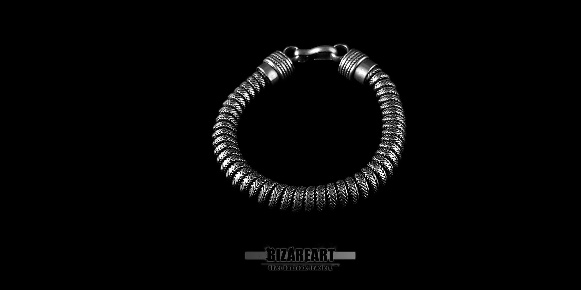 Angled view of the silver bracelet highlighting the matte, hand-finished oxidation on the rounded links.