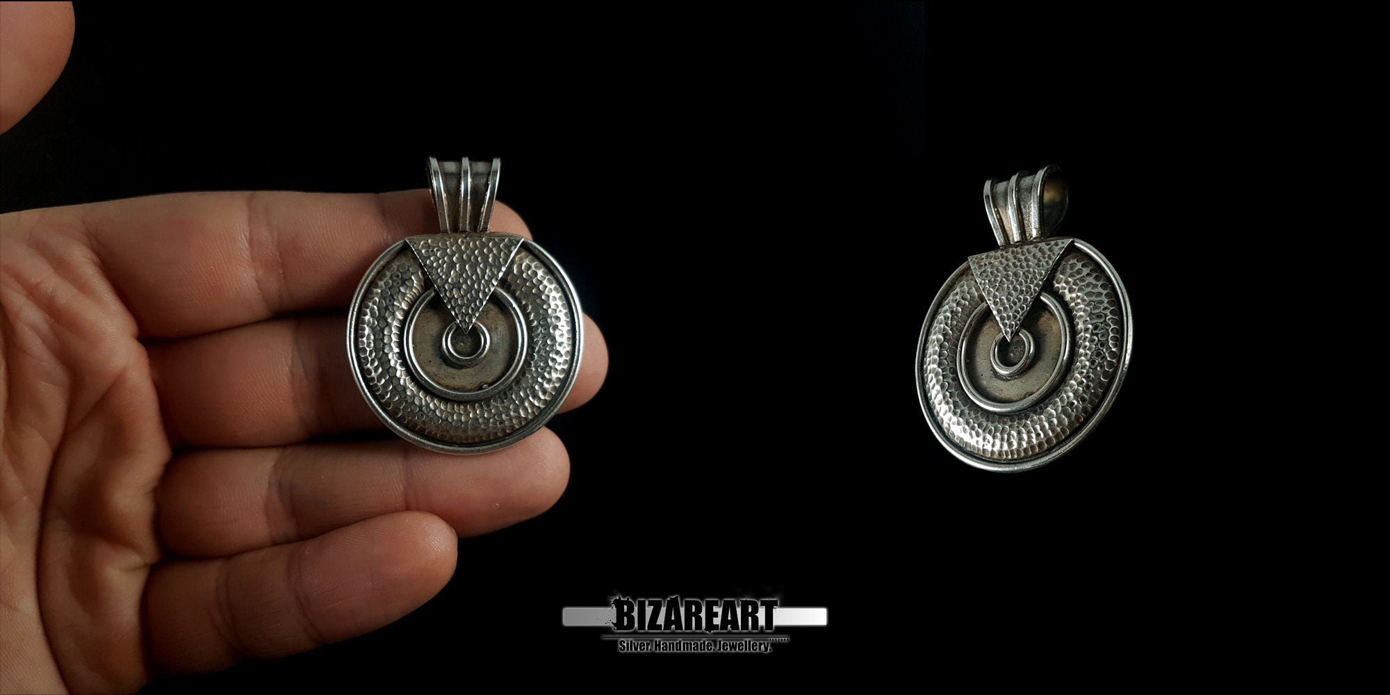 Handheld view of two round silver pendants to demonstrate real-world scale, size comparison, and the artisanal handcrafted finish.