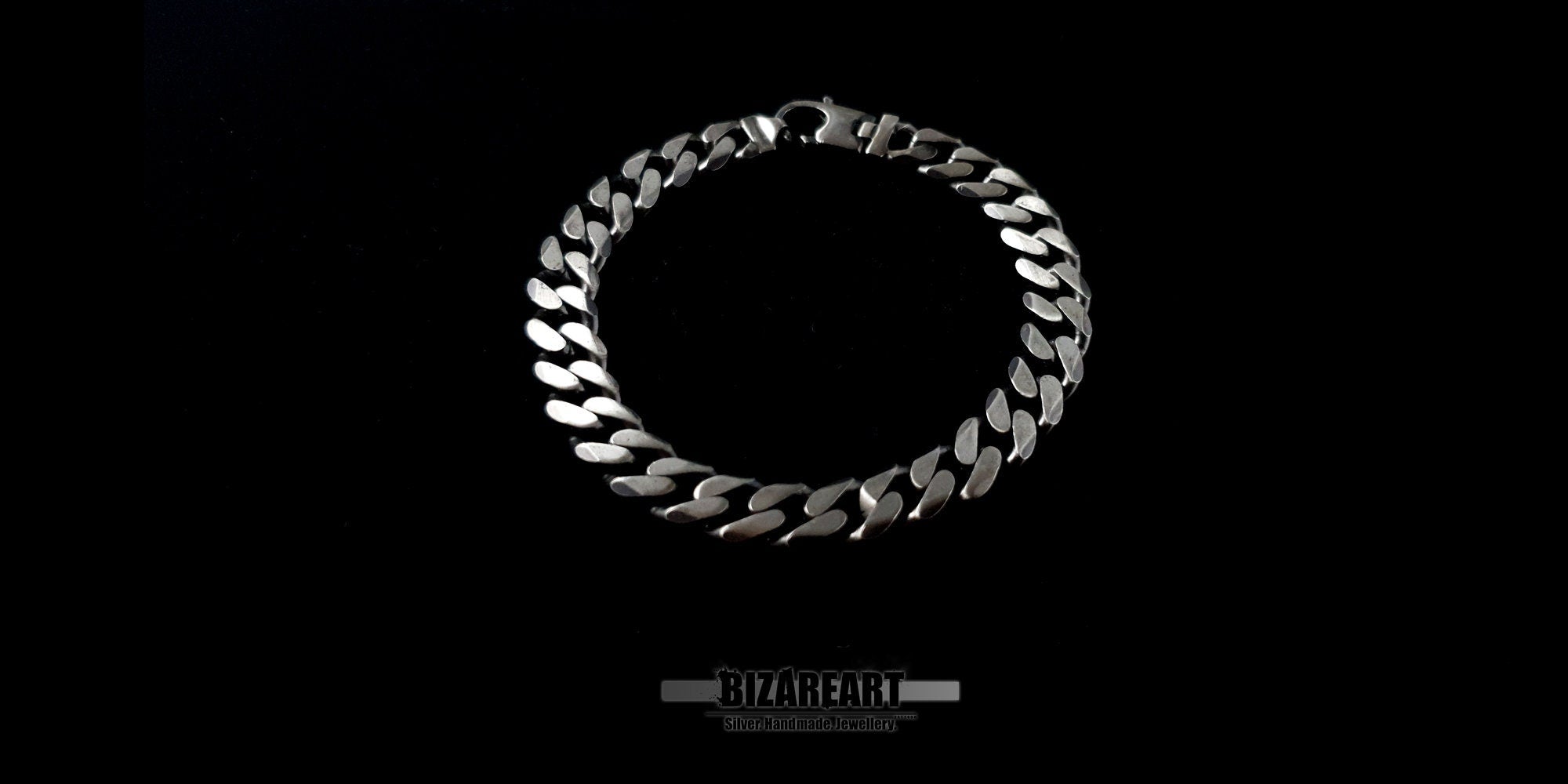 Close-up overhead shot of a circular sterling silver chain bracelet highlighting the symmetrical plait and secure hook closure.
