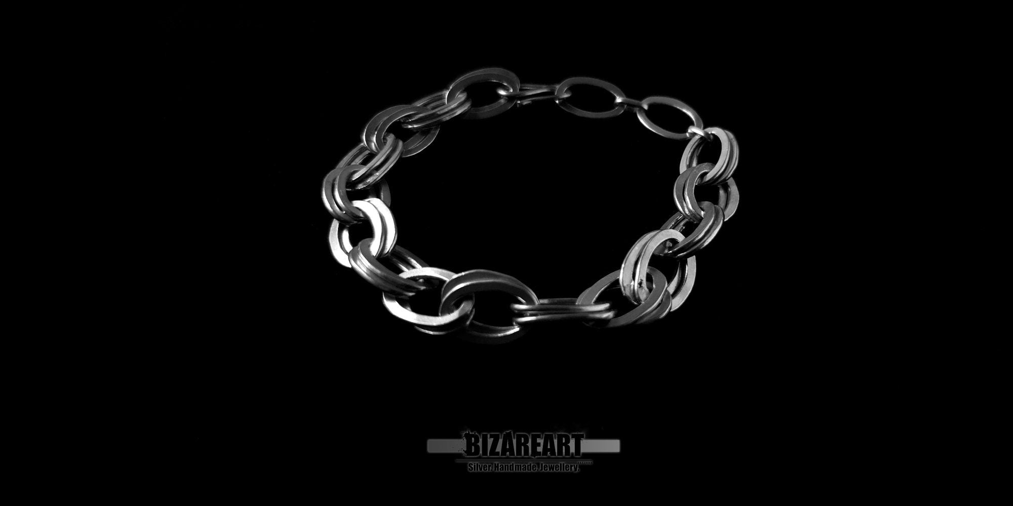 Three-quarter perspective of the silver bracelet emphasizing the thickness of the links and the integrated hook fastening system.