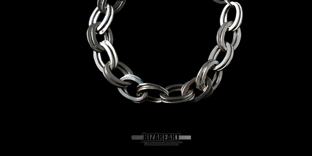 Close-up detail of the interlocking double links of a 925 sterling silver bracelet highlighting the high-shine polished finish.