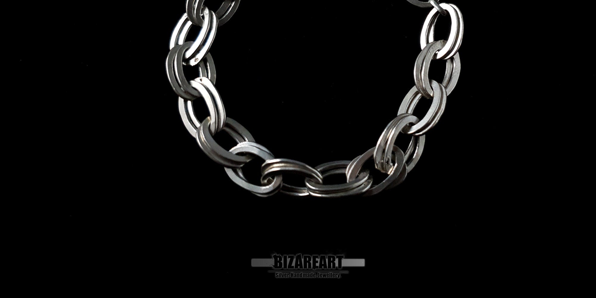 Close-up detail of the interlocking double links of a 925 sterling silver bracelet highlighting the high-shine polished finish.