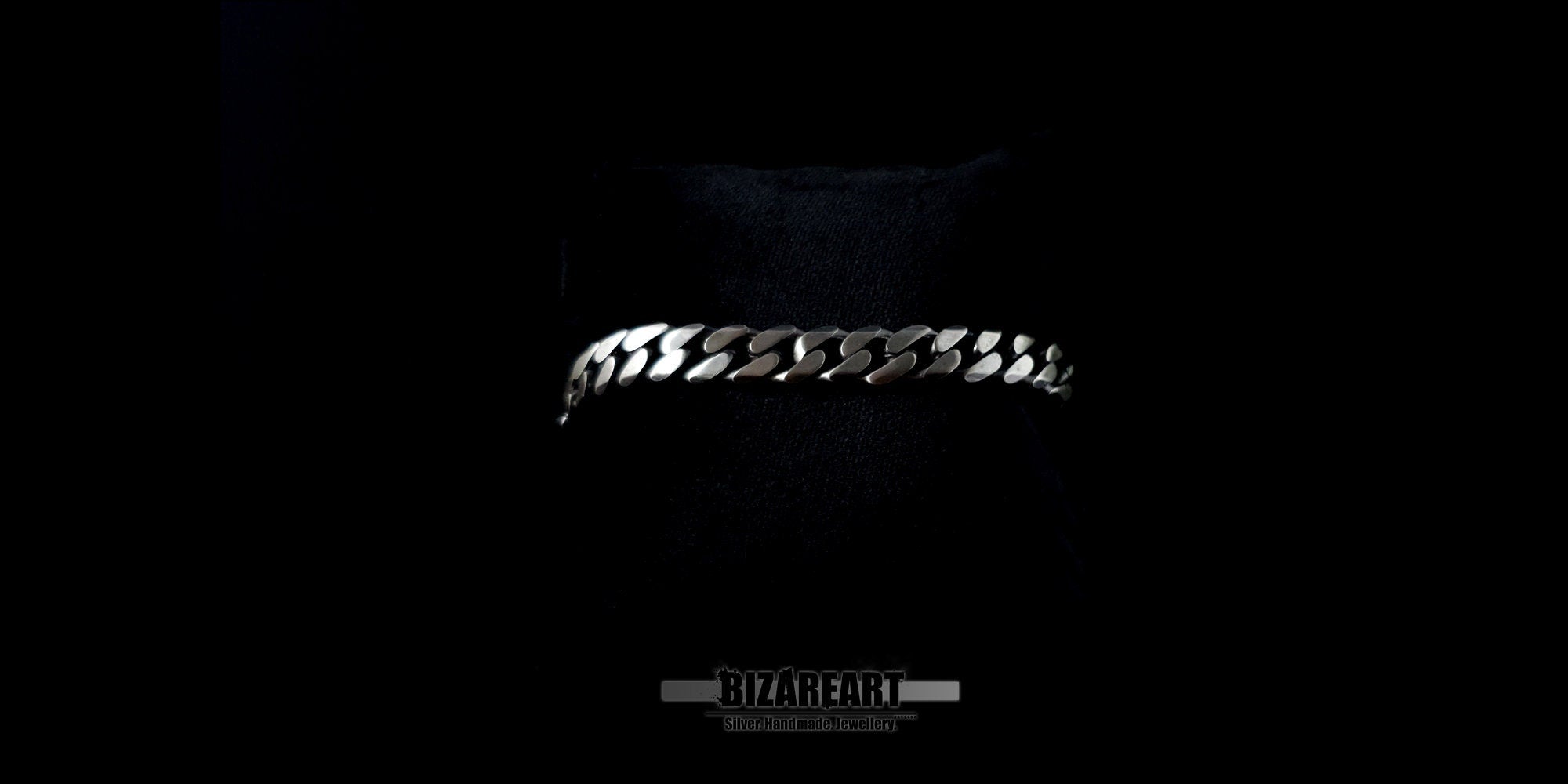 Side profile of the silver curb bracelet resting on a surface, emphasizing the 1.7mm thickness and polished edges.