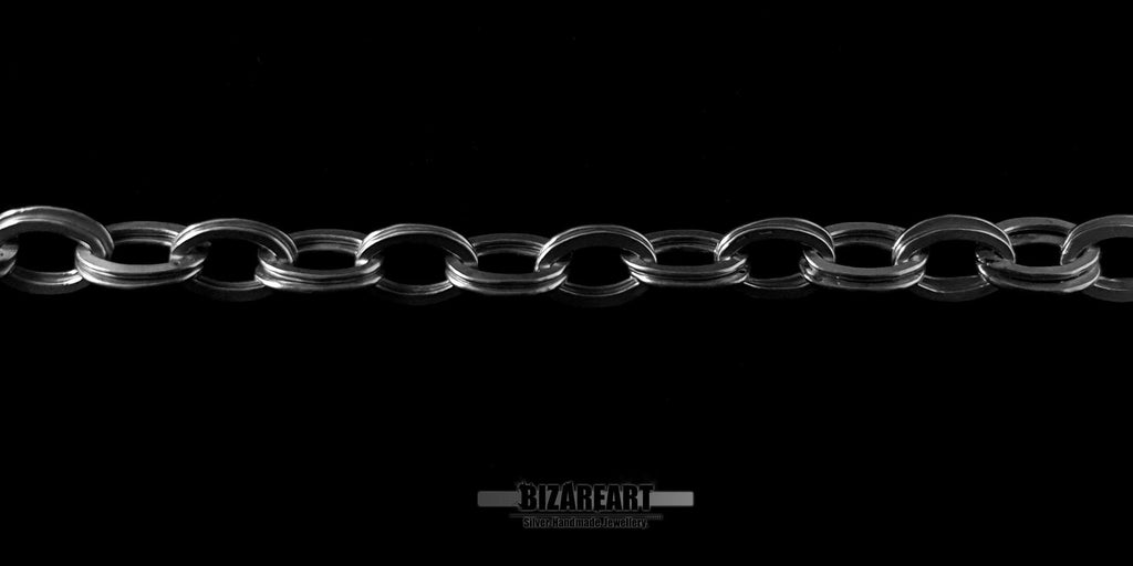 Side profile of the double loop sterling silver chain laid flat to demonstrate the industrial-meets-elegant design.