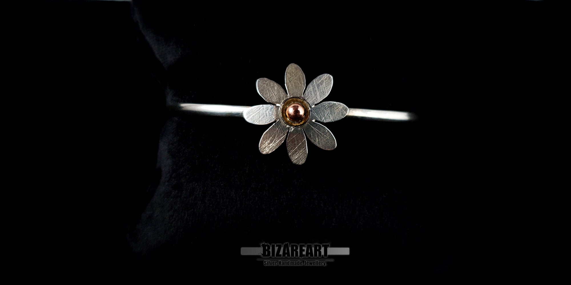 Minimalist sterling silver wire cuff bracelet featuring a mixed-metal copper and gold-plated flower charm.