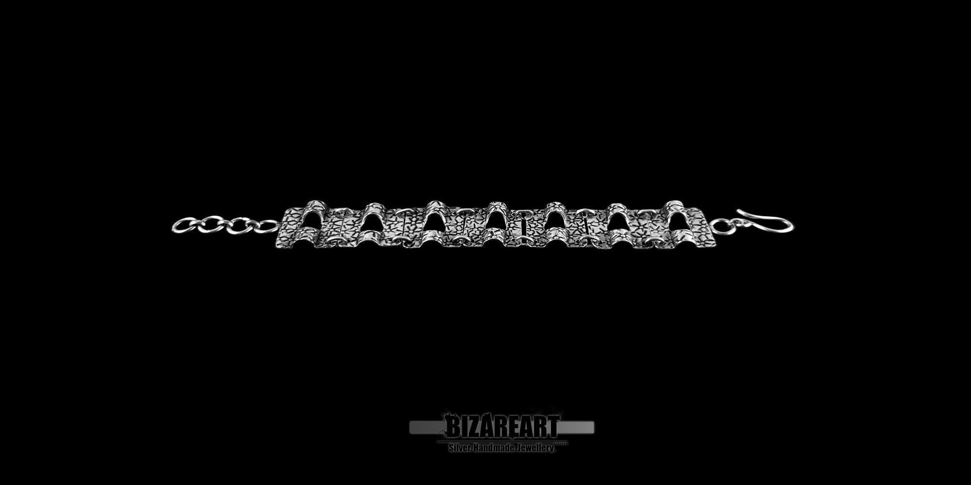 Full length view of the artisan silver bracelet laid flat, showing the 7 distinct star-engraved panels connected by silver hoops and the hook clasp.