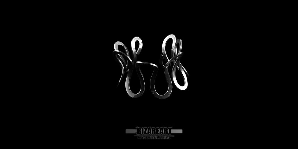 A product image capturing the sterling silver cuff bracelet positioned to clearly show its open-back design. The fluid, looping metallic lines are silhouetted against a solid black backdrop, highlighting the symmetry and wearable ergonomics of the piece.