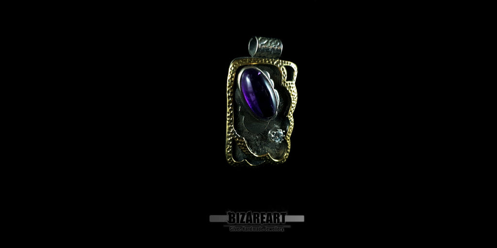 Bizareart handmade silver pendant featuring a large oval Amethyst in a bezel setting, a sparkling Cubic Zirconia, and an intricate granulated silver background framed in a gold-plated decorative border.
