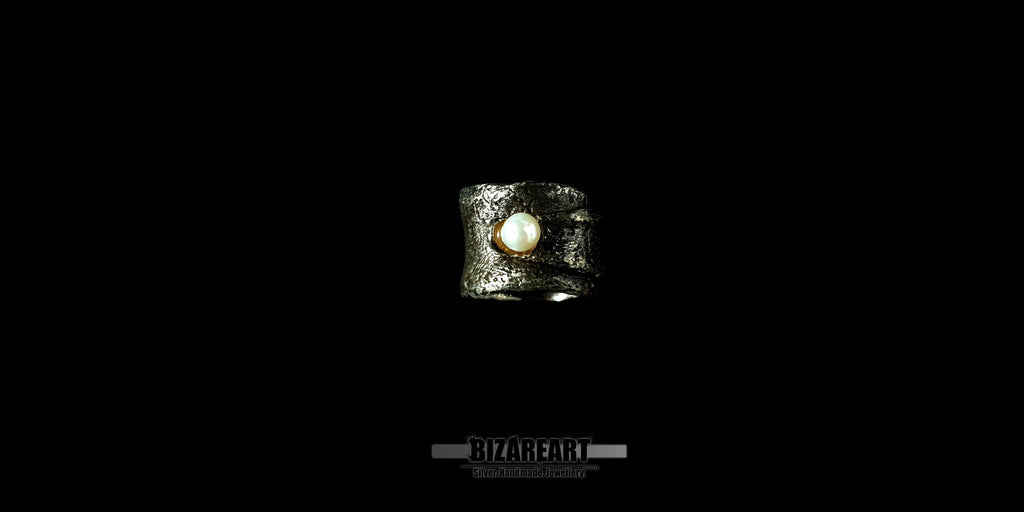 Top down view of the handmade Bizareart wrap ring in oxidized sterling silver with a raw, sculptural texture and a single white freshwater pearl set against a black background.