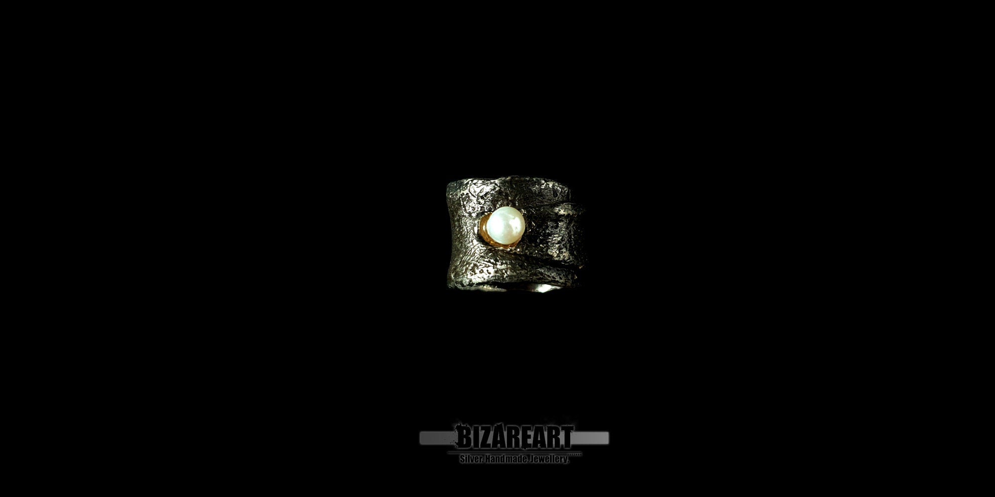 Top down view of the handmade Bizareart wrap ring in oxidized sterling silver with a raw, sculptural texture and a single white freshwater pearl set against a black background.