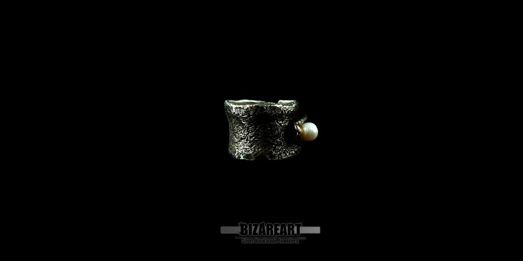 Side view of the handmade Bizareart wrap ring in oxidized sterling silver with a raw, sculptural texture and a single white freshwater pearl set against a black background.