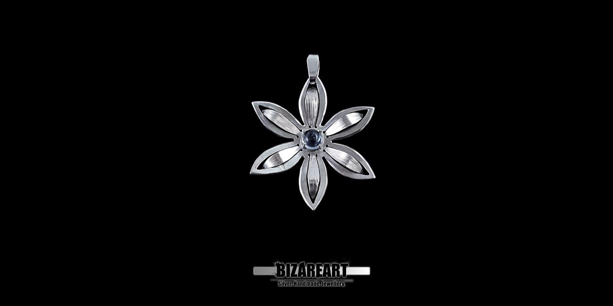 Minimalist silver flower necklace charm with detailed petal engravings and a natural blue gemstone.