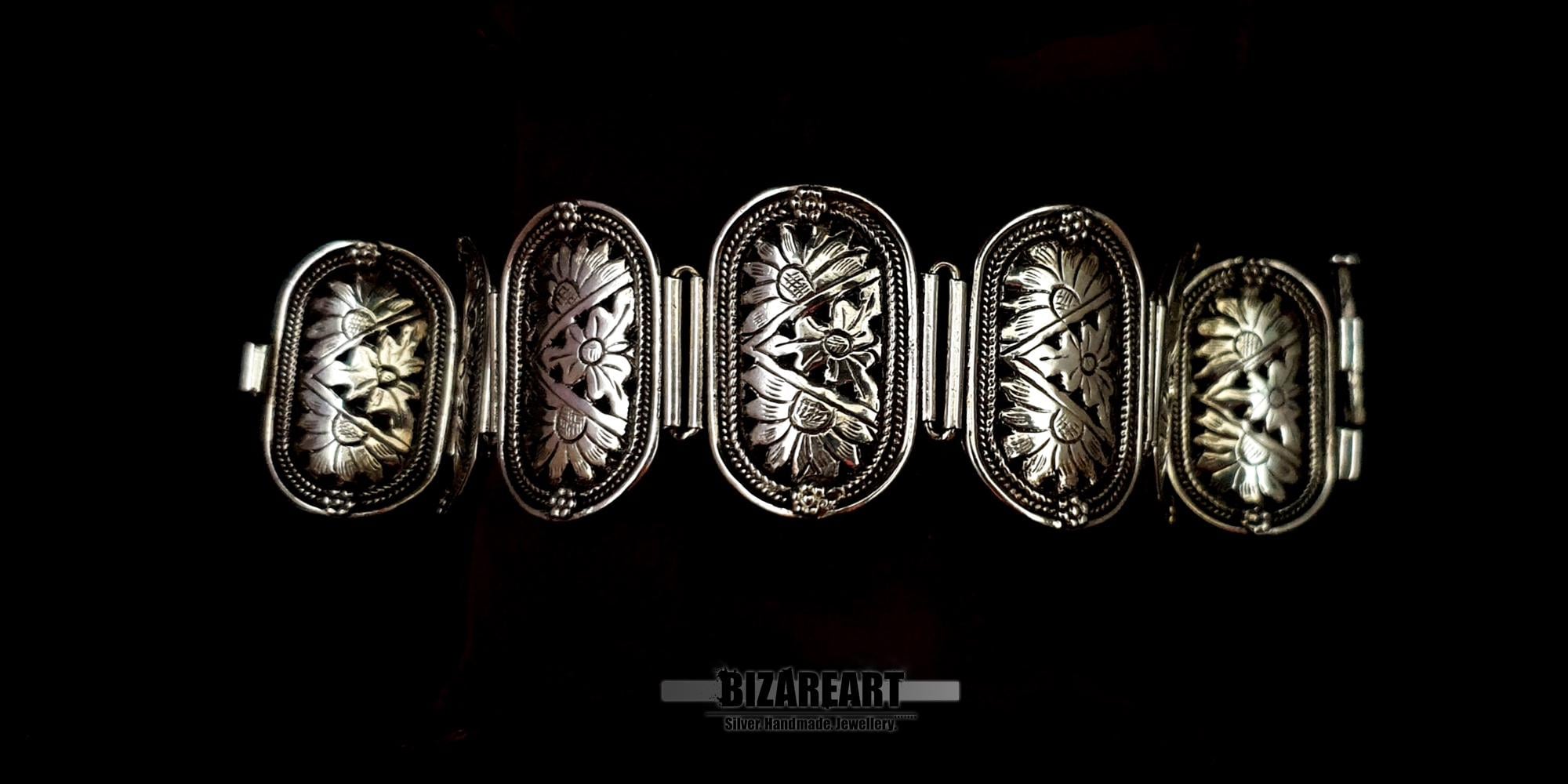 High-shine sterling silver panel bracelet laid out flat to show five of its intricate floral engraved links.