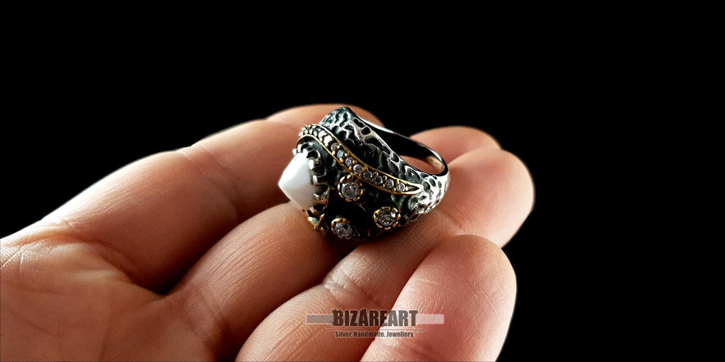 Close-up of a person holding the large white agate and silver statement ring to show scale and wearability.