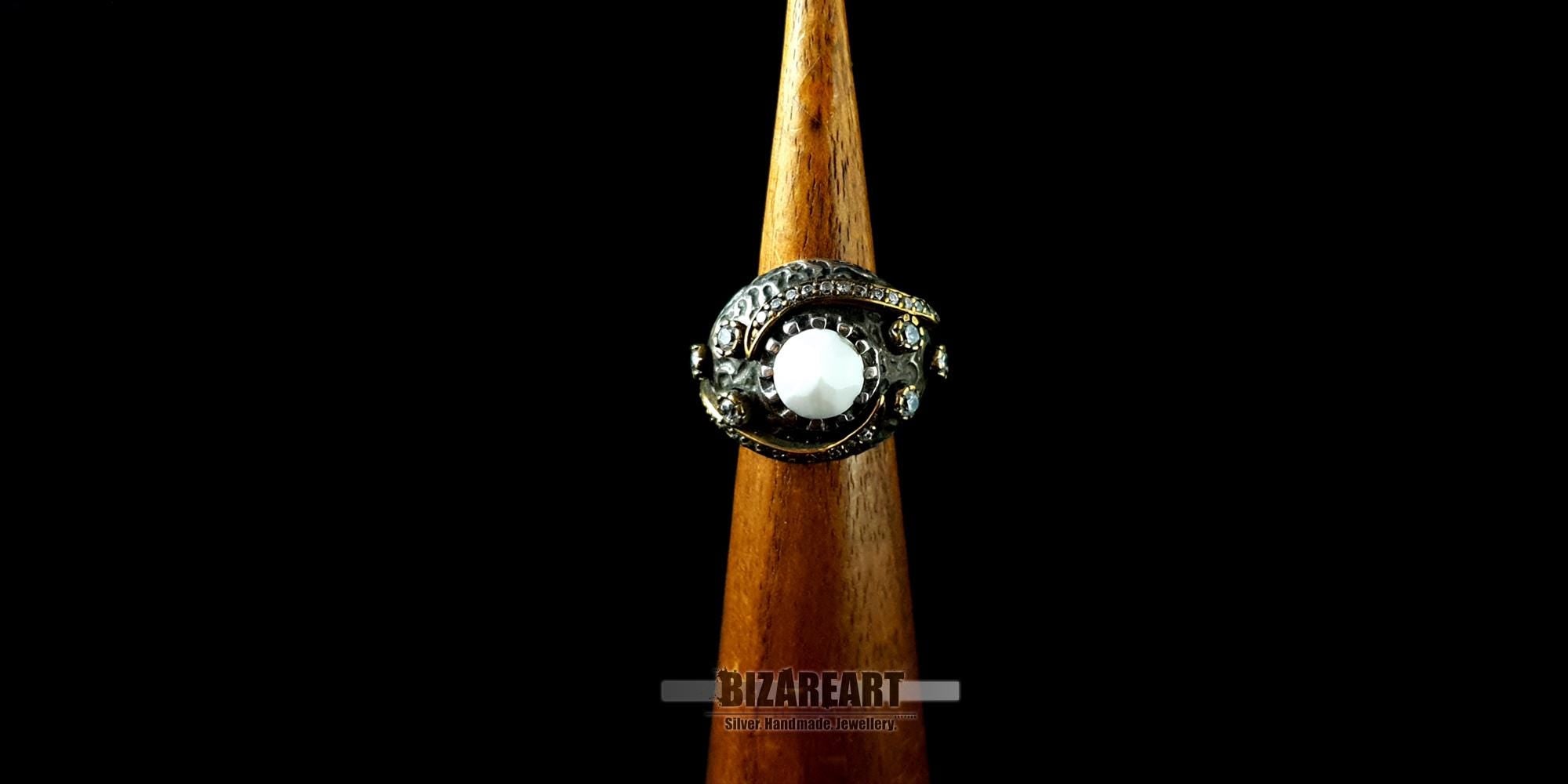 Front view of the gold-plated white agate ring displayed on a wooden jewelry cone display.
