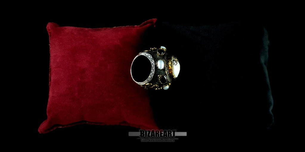 Detailed view of a statement dome ring highlighting the bezel-set onyx and white pearl accents.