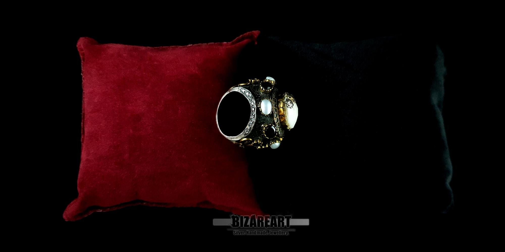 Detailed view of a statement dome ring highlighting the bezel-set onyx and white pearl accents.