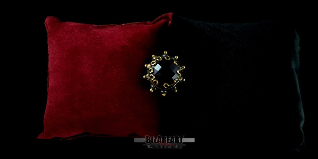 Top-down view of a handmade sterling silver and gold-plated amethyst dome ring resting on a luxury red velvet cushion.