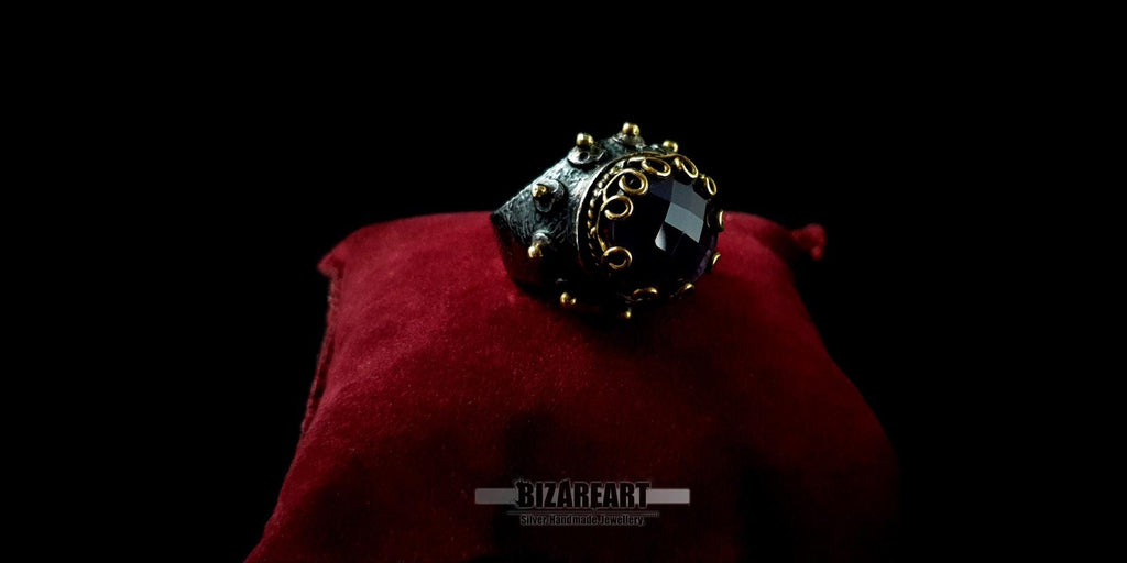 Front view of a gothic-inspired dome ring showcasing a gold-plated crown bezel and a deep purple amethyst center stone.
