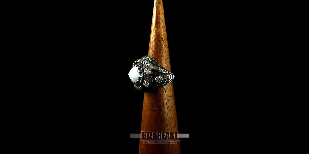 Side view of the textured oxidized silver band and zirconia stone accents on a wooden ring cone.