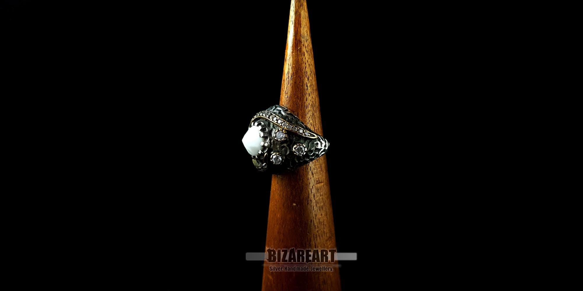 Side view of the textured oxidized silver band and zirconia stone accents on a wooden ring cone.