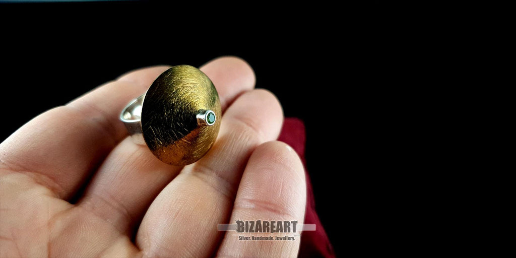 Rear view of the ring on a red cushion, displaying the polished silver band and internal construction.