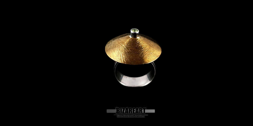 Angled side view of the cymbal ring highlighting the elevation of the gold disc above the silver band.
