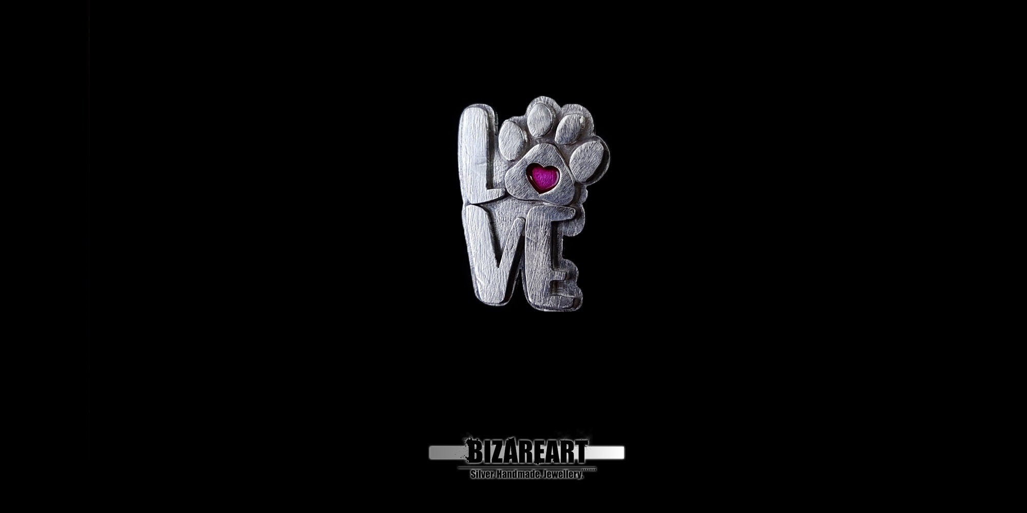 Front-facing view of the silver "LOVE" paw pendant, showcasing the rugged, organic texture of the silver.