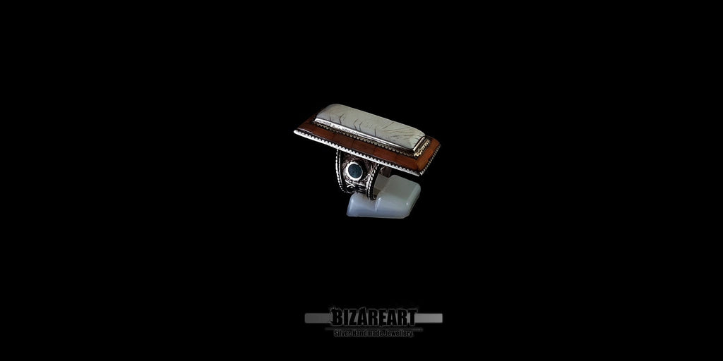 Large Tibeto-Nepalese silver statement ring featuring a long rectangular white conch shell cabochon, set on a wide engraved band against a black background.