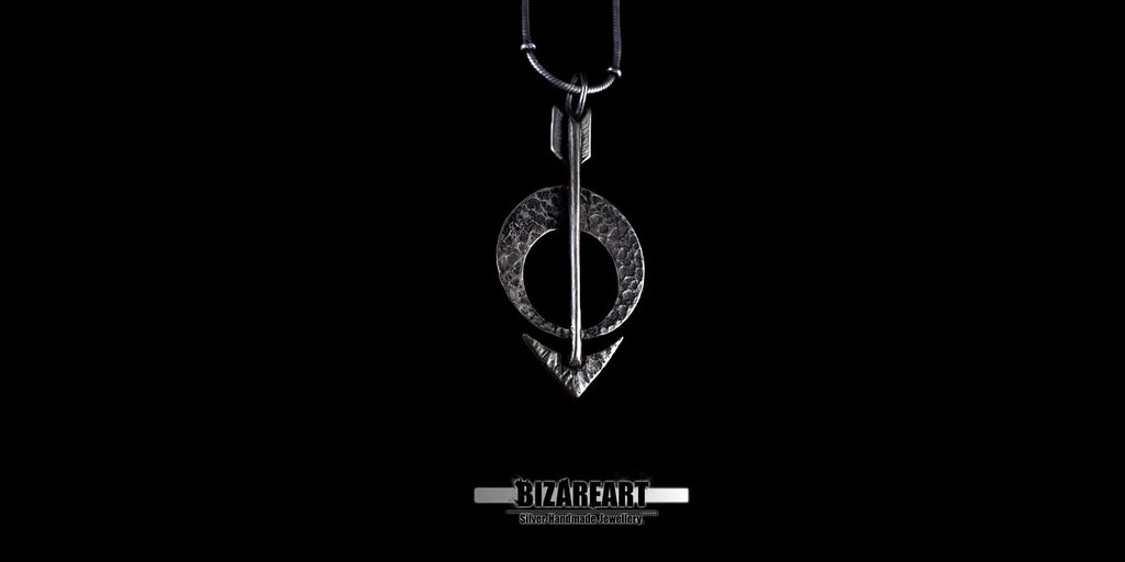 High-angle studio shot of the oxidized silver arrow pendant hanging vertically.