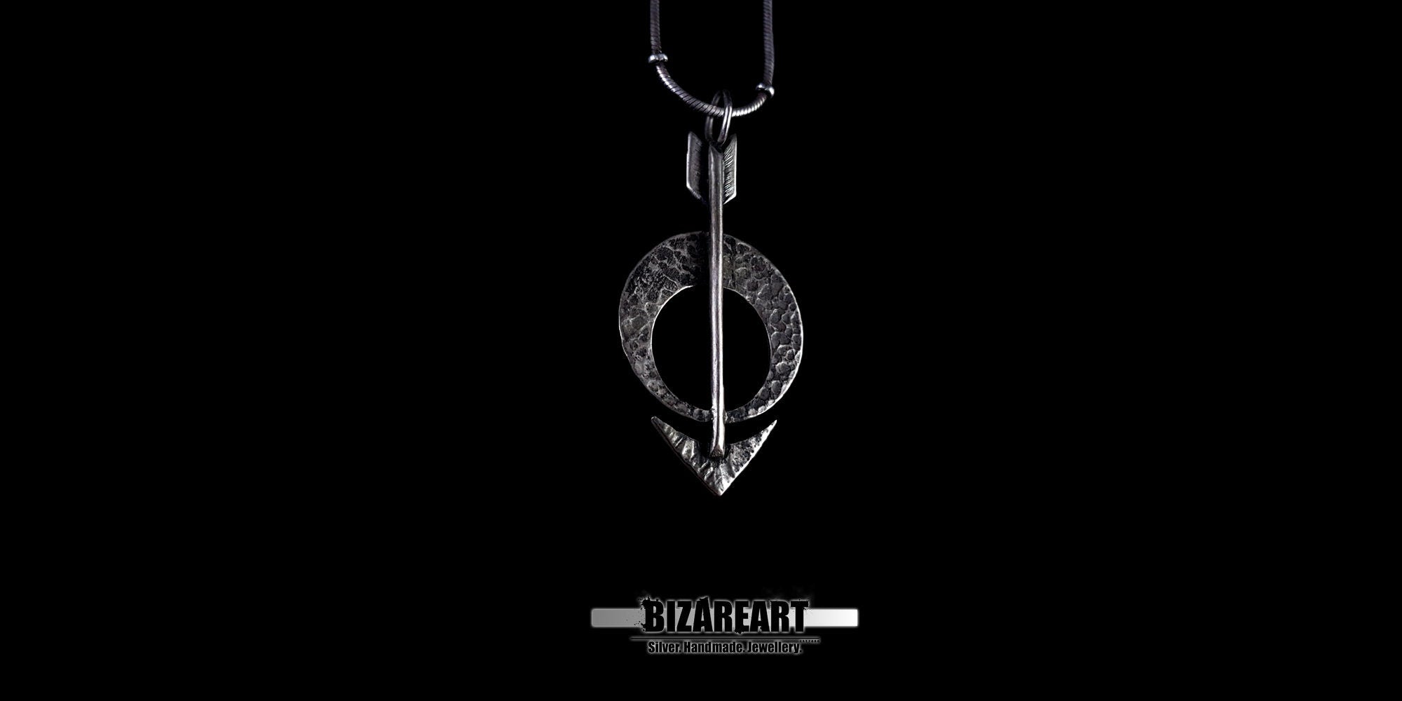 High-angle studio shot of the oxidized silver arrow pendant hanging vertically.