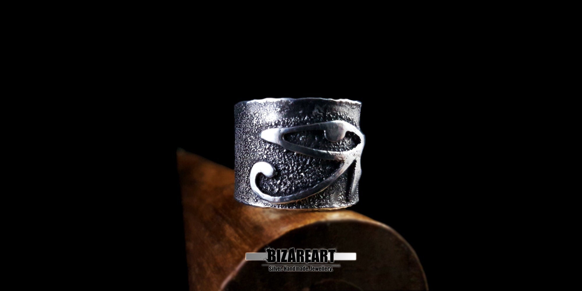 Macro detail of the oxidized finish and hand-carved Eye of Ra ring