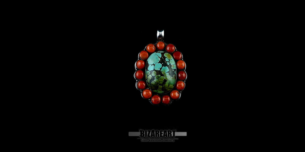Close-up of a unique Southwestern style turquoise and red coral sterling silver pendant showcasing the natural black matrix patterns in the center gemstone.
