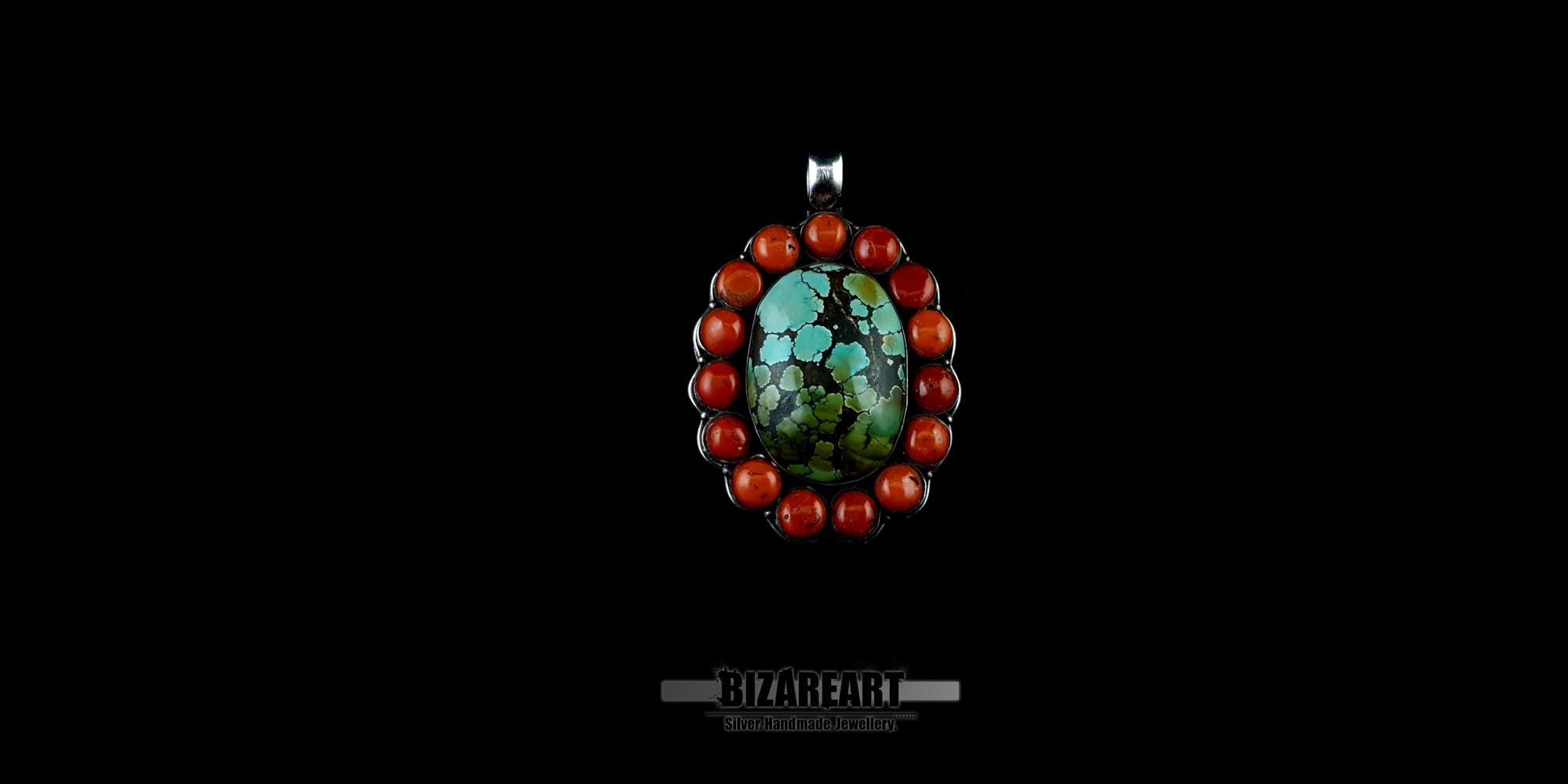 Close-up of a unique Southwestern style turquoise and red coral sterling silver pendant showcasing the natural black matrix patterns in the center gemstone.