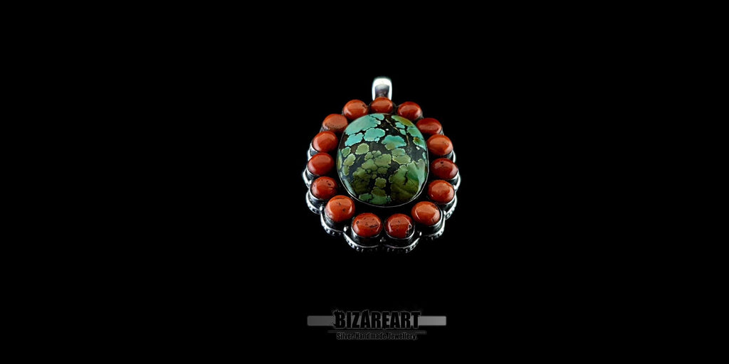 Front view of a large handcrafted statement pendant with a vibrant turquoise centerpiece and a red coral bead border against a solid black background.