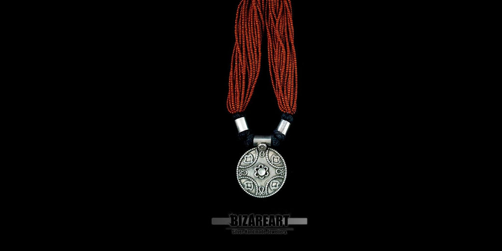 Symmetrical product shot of a red garnet and oxidized silver statement necklace, highlighting the craftsmanship of the hand-threaded beads.