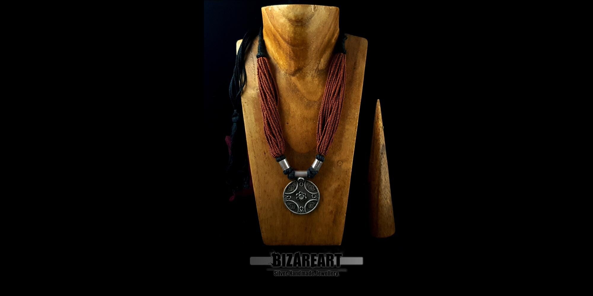 Traditional Indian tribal necklace displayed on a wooden jewelry bust to illustrate the drape and scale against a natural neckline.