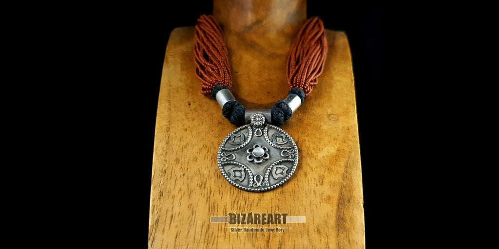 Traditional Indian tribal necklace displayed on a wooden jewelry bust to illustrate the drape and scale against a natural neckline.
