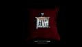 A square, handcrafted sterling silver "forest" pendant with layered metal textures and copper accents, resting on a plush dark red velvet cushion against a black background.