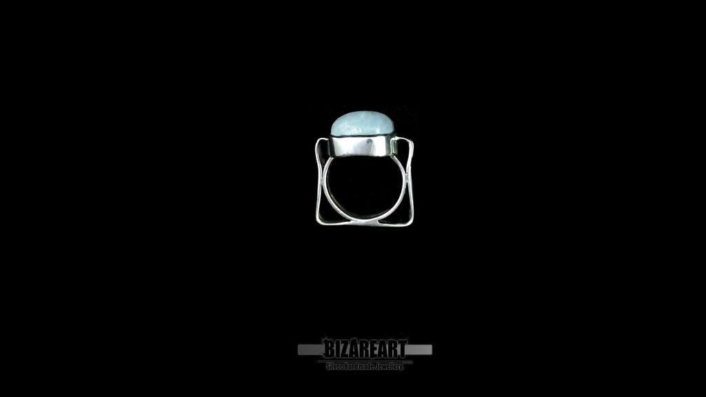 Bird's-eye view of the moonstone ring showing the blue adularescence (glow) of the gemstone and the symmetrical silver frame.